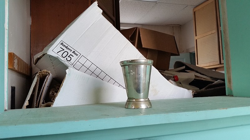 A lone silver cup left on a countertop stands out from the rest of the odds and ends.