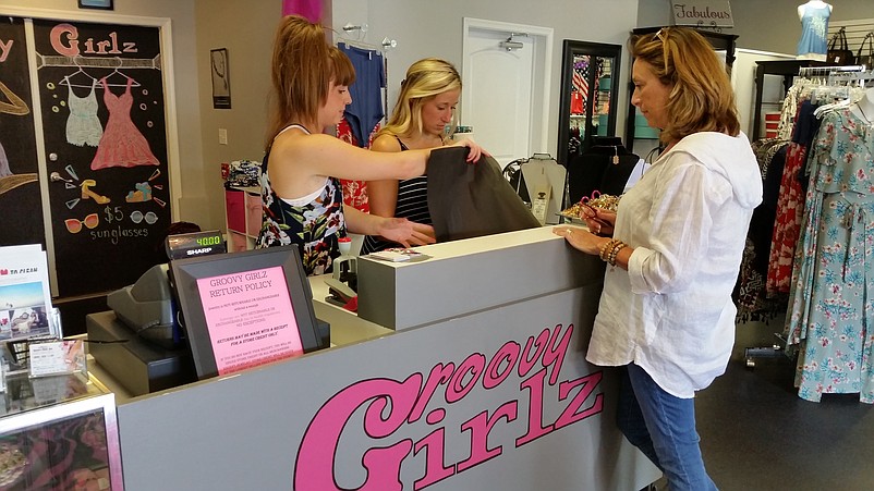 From left, Groovy Girlz employees Cassidy Buch and Nikki Trofa wait on customer Monica McAfee.