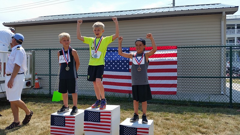 Hugo Rowbotham, in yellow shirt, of Bryn Mawr, Pa., celebrates his win in the long jump competition for 9-year-old boys.