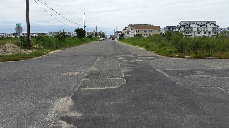 38th Street awaits a repaving where the new stormwater pipe was buried and covered over with a temporary layer of asphalt.