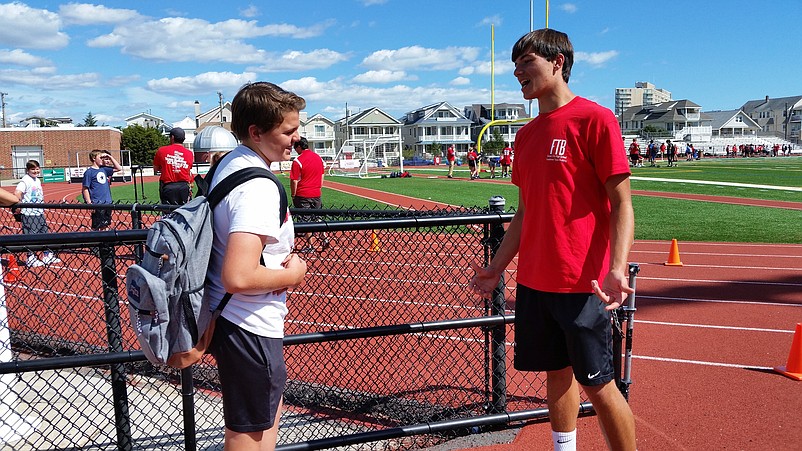 Jacob Stryker, left, a 14-year-old freshman, gets some pointers from his brother, Paulie, a 17-year-old senior.