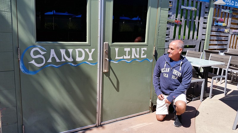 Ocean Drive co-owner Ralph Pasceri looks at the line that marks the height of the floodwaters unleashed by Hurricane Sandy in 2012.