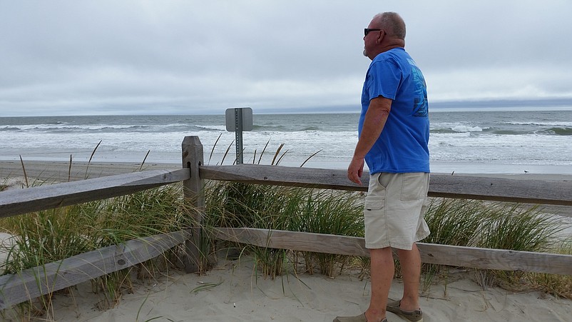 Frank Donahue, a vacationer from Philadelphia, peers out on the choppy surf.