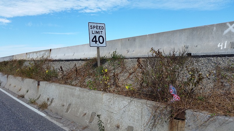 High weeds have also sprouted between the concrete barriers that separate the existing lanes and the new, elevated roadway that will open in November.