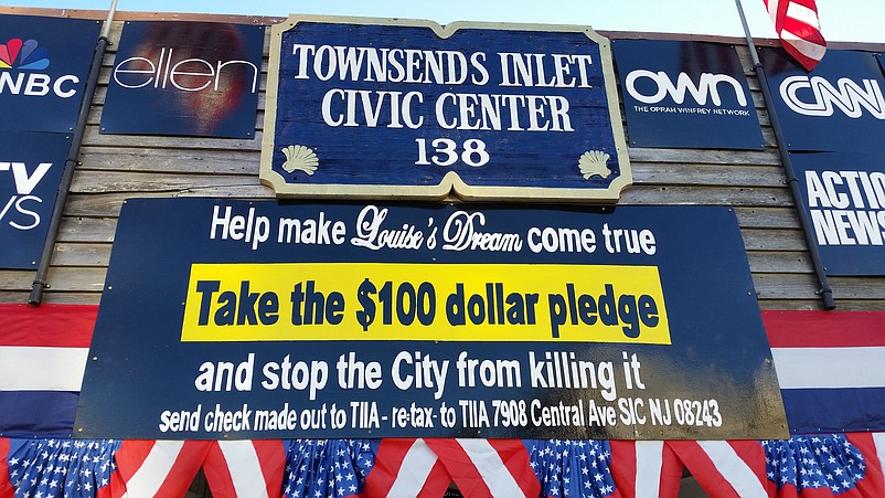 One sign on the civic center solicits $100 donations from the public to help save the landmark building on 85th Street.