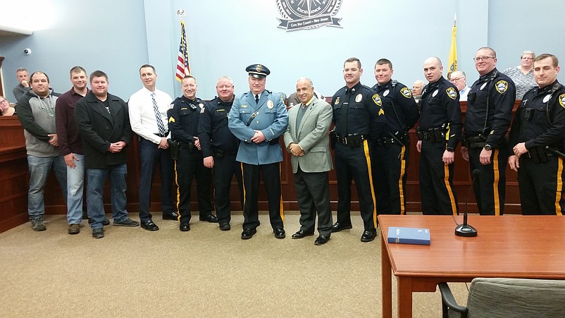 Sea Isle police officers join with McQuillen and Desiderio, center, to celebrate the new chief's appointment.