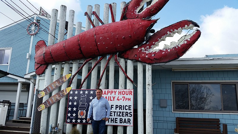 The giant crustacean decoration looms over Lobster Loft owner James Bennett.