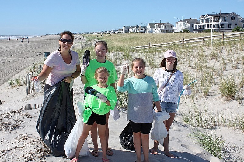 Families, individuals, businesses, students and members of civic organizations are invited to participate in Sea Isle City’s annual Spring Beach Clean-Up on Saturday, April 21. Shown holding a variety of items they collected from the beaches and dunes during last year’s Beach Clean-Up are (from left) Colleen Dugan-Schearer, of Reading PA; Leila Black, 12, of Middletown, NJ; Alison Schearer, 6, of Reading, PA; Emily Schearer, 9, of Reading, PA; and Katlyn Baker, 16, of Levittown, PA. (photo provided by Sea Isle City Public Relations)