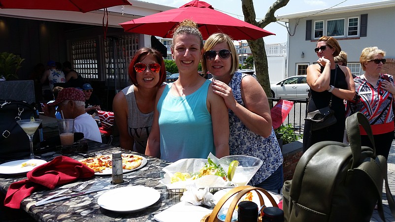 At Henri's Bar, Dawn Hillen, center, shares drinks and a pizza with sisters Theresa and Jennifer Gillespie.