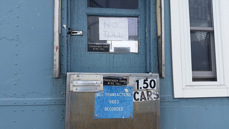 A handwritten "No Toll" sign greets motorists Wednesday in the window of the toll plaza.