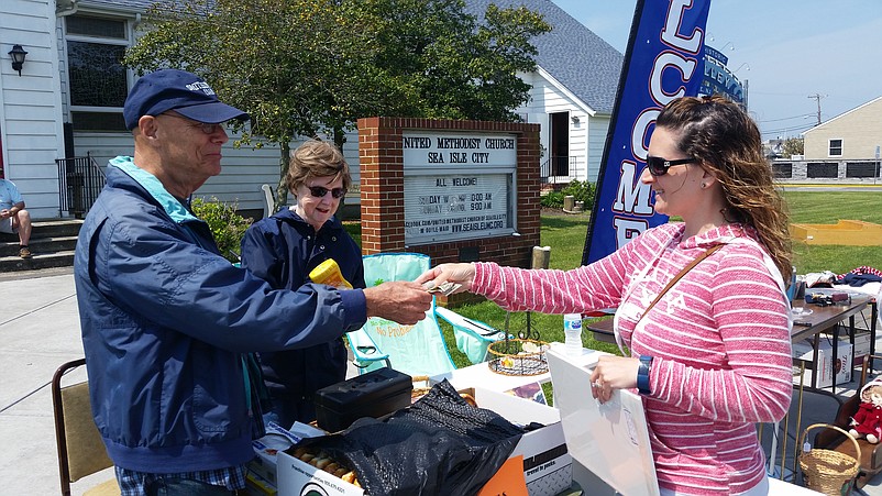 Michele Hyczka, right, of Stratford, Camden County, buys a photo from United Methodist Church volunteers Wayne Guard and Pat Ogle.