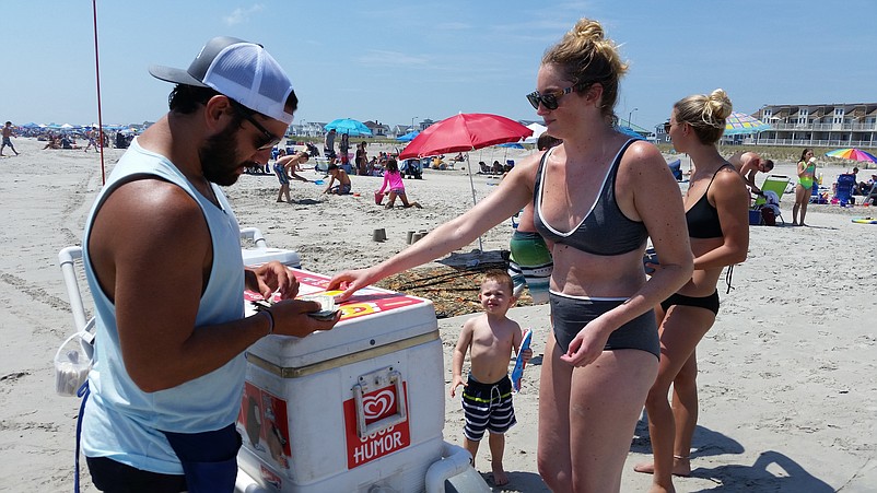 Saved from having to purchase a beach tag on Wednesday, Ashlynn Snyder uses her money to buy an ice cream from the "Fudgy Wudgy" man.