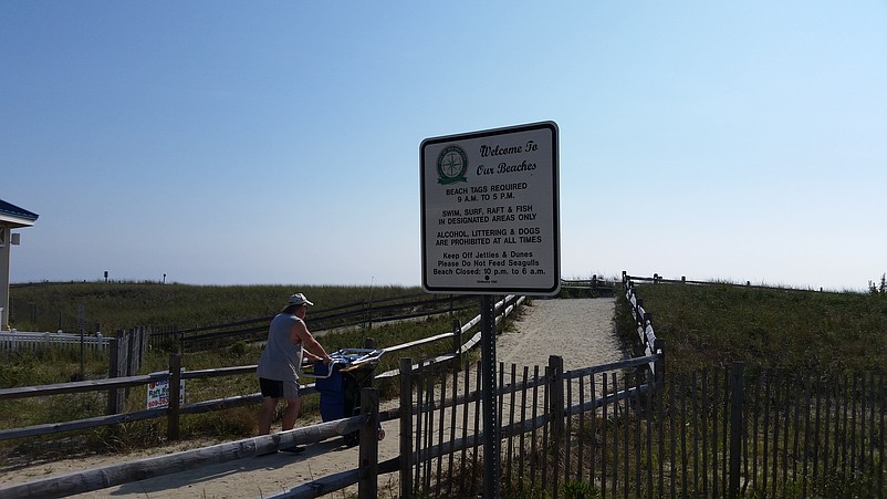 A sign on a walkway leading to the beach makes it clear that alcoholic beverages are not allowed.