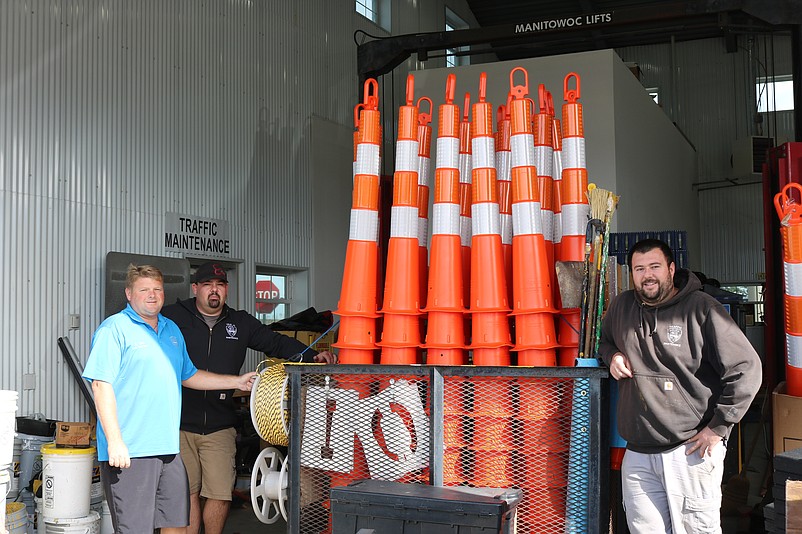 From left, Teefy and fellow traffic maintenance workers Matt Steelman and Jimmy Lane stand by some of the 250 safety cones that will used at parades.