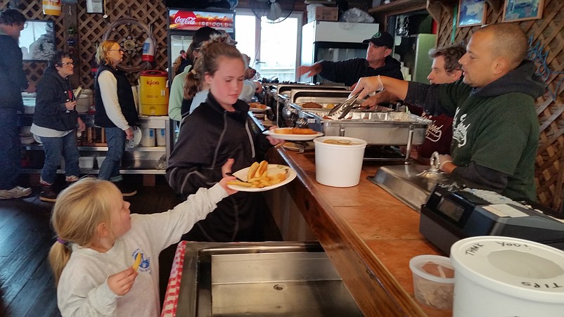 Volunteers enjoy a complimentary buffet lunch at Mike's Seafood and Dock Restaurant after the beach cleanup.