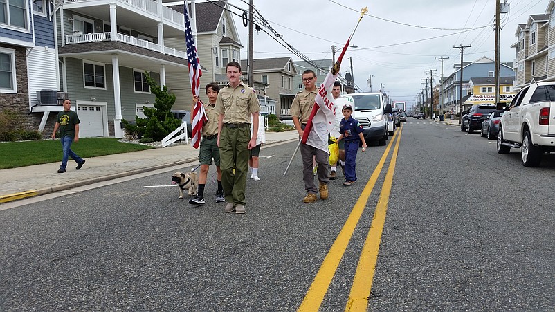 Members of Boy Scout Troop 76 and Cub Scout Pack 76 carry the colors while marching down Landis Avenue.