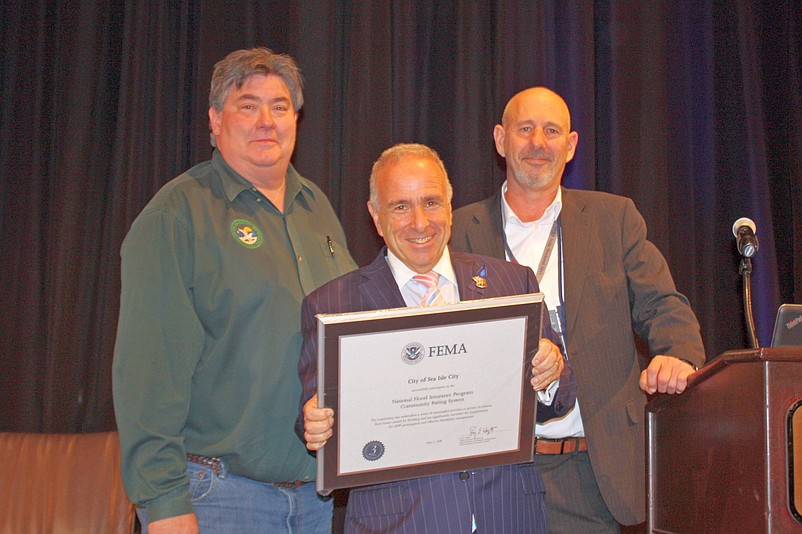 From left, Sea Isle Floodplain Manager Neil Byrne and Sea Isle Mayor Leonard Desiderio accept the award from FEMA representative  Scott Duell.