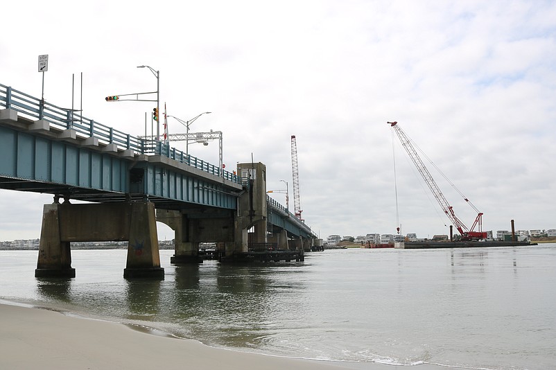 Construction crews are using large cranes that sit on top of barges anchored in the inlet.