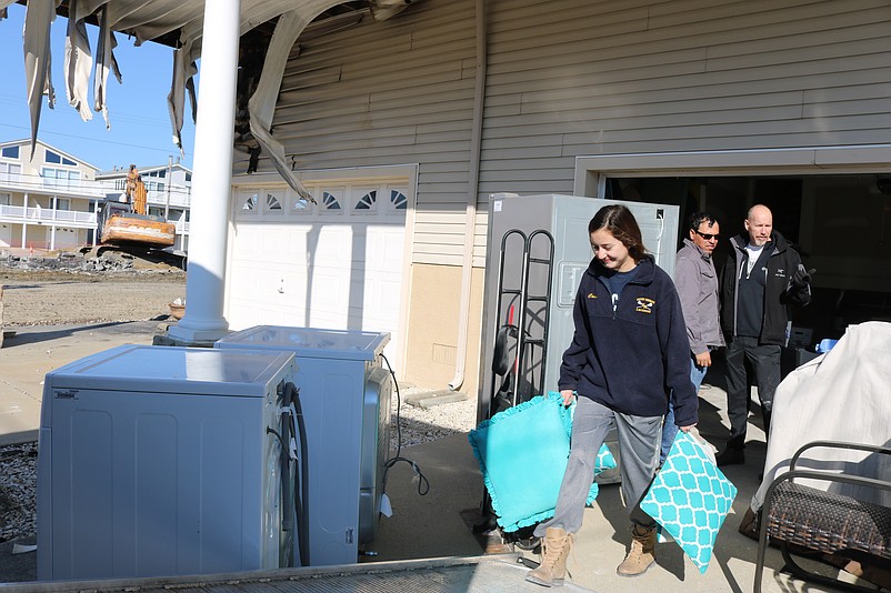 Stephanie Peyton removes some pillows that were saved from her family's badly damaged house.