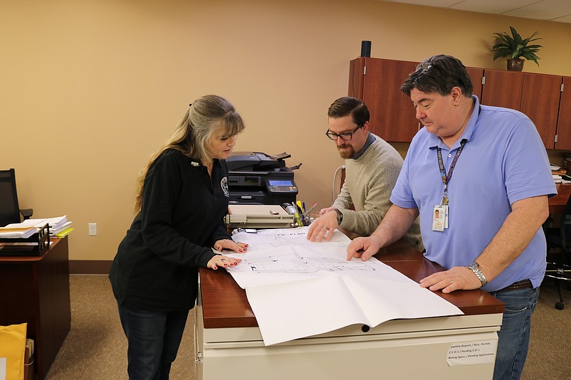 Sea Isle Construction Officer Neil Byrne, right, looks over construction plans with Genell Ferrilli, the planning and zoning board secretary, and Bryan Cottrell, code enforcement officer.