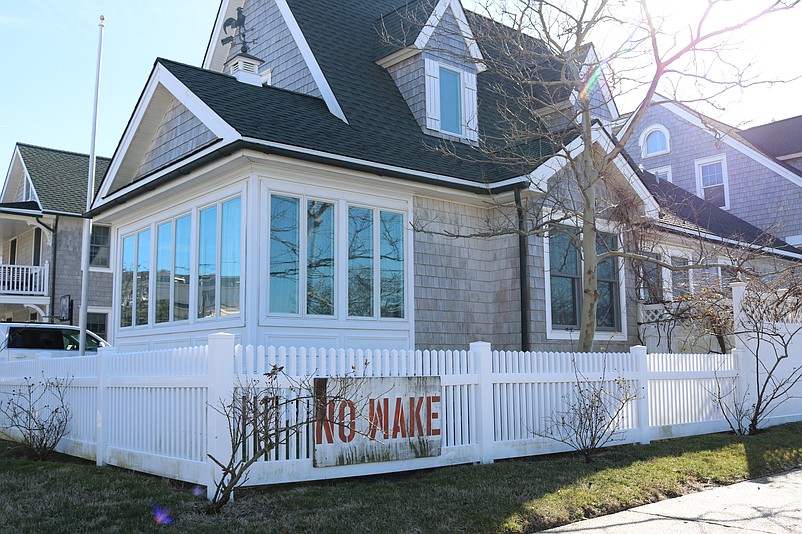 A homeowner at the corner of 45th Street and Central Avenue has a "No Wake" sign that urges motorists not to speed through flooded streets.