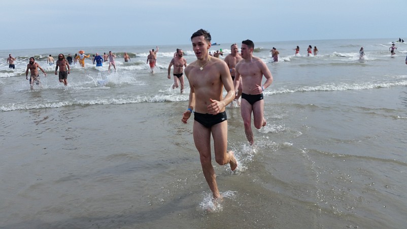 Plungers head out of the surf.