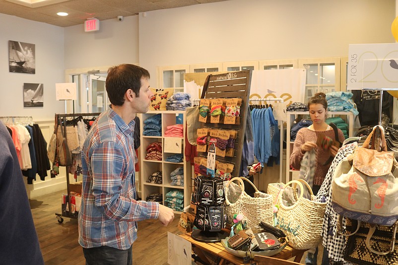 Wes Kazmarck, owner of the Birdcage boutique, talks with a customer.