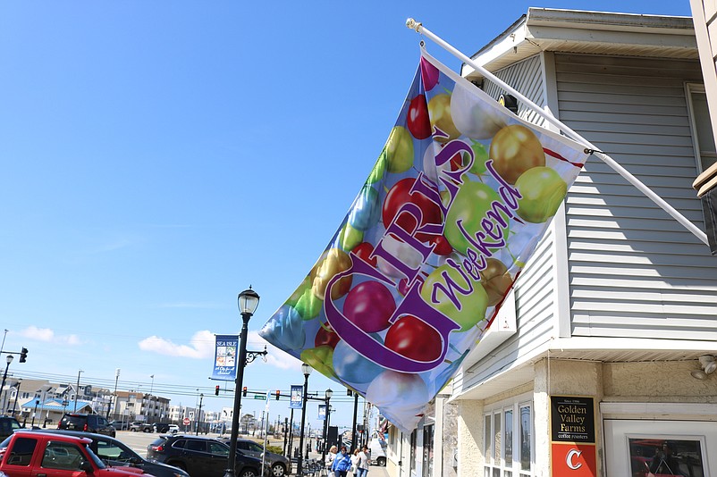 Colorful "Girls Weekend" flags fly in front of participating businesses.