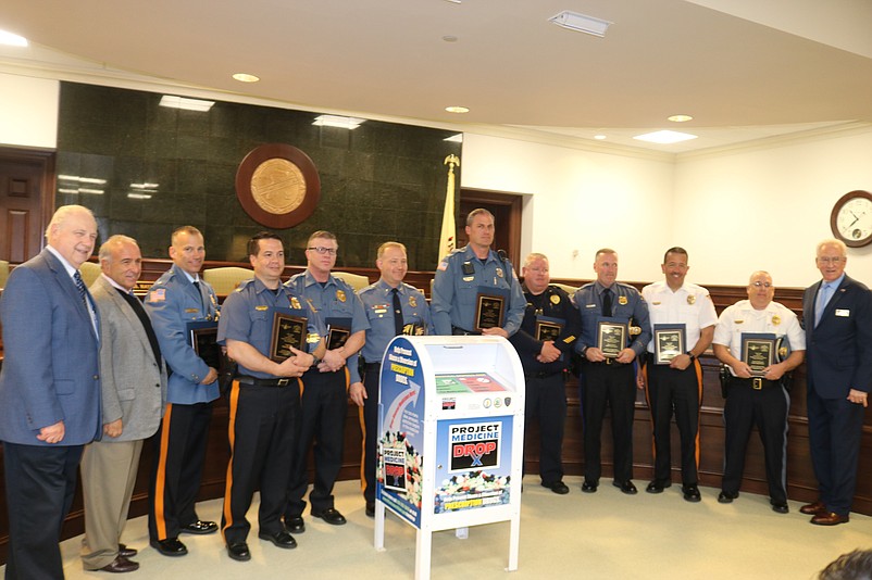 Law enforcement officials, dignitaries and health officials take a group photo at the end of the press conference.