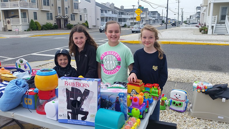 From left, Matthew Boyle, his sister, Regan, Brenna Morrison and Madalyn Wilbekaitis stand next to a table filled with toys for sale.