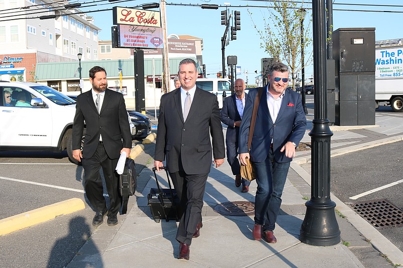 Developer Christopher Glancey, right, and his representatives pass by the LaCosta Lounge site on their way to City Hall for the zoning board meeting.