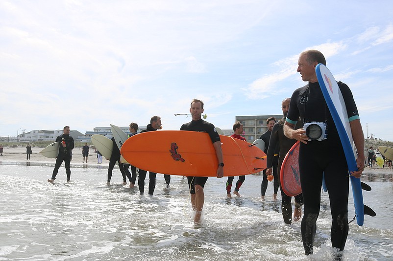 Carrying flowers and their boards, surfers wade into the ocean to begin their "paddle out" ceremony in Matt Vecere's honor last year.