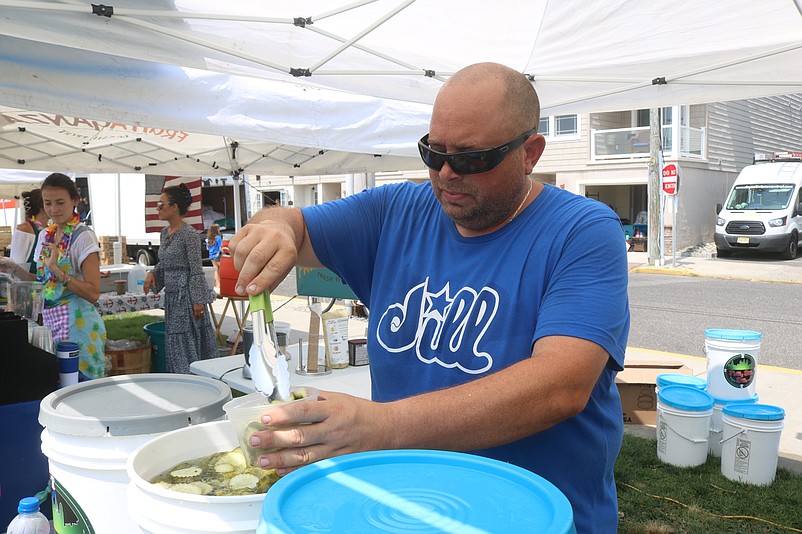 Joe Palumbo, owner of Philly Bill's Dills, scoops pickles into containers.