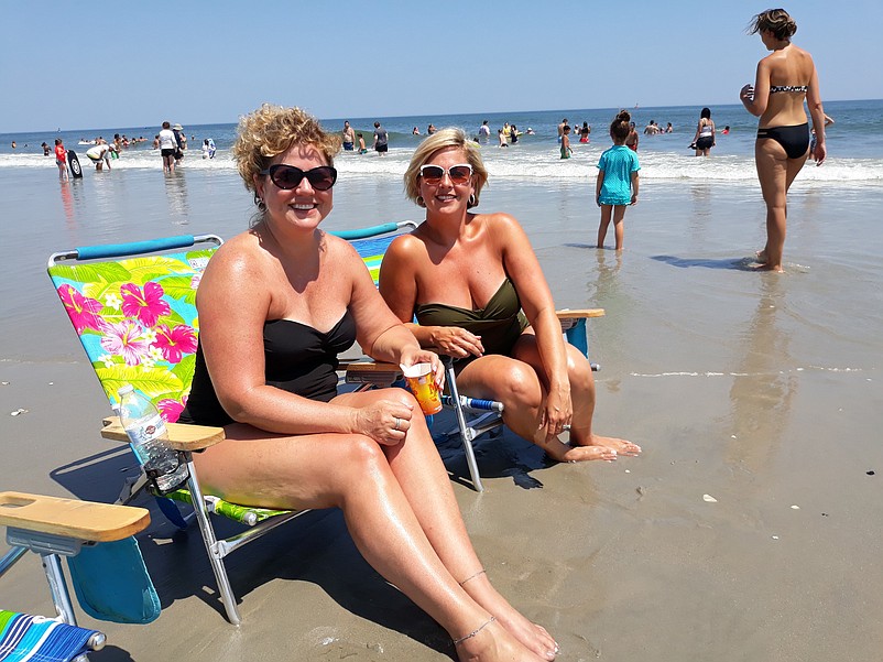 Tina Belbin, left, and Nicole Scirrotto park their beach chairs next to the water.