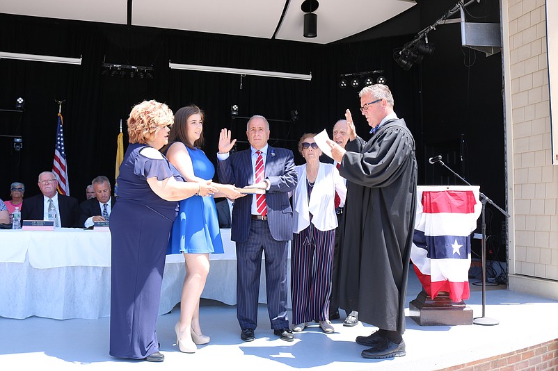 Mayor Leonard Desiderio, center, is sworn in for his eighth term by Judge Michael Donohue as his family watches.