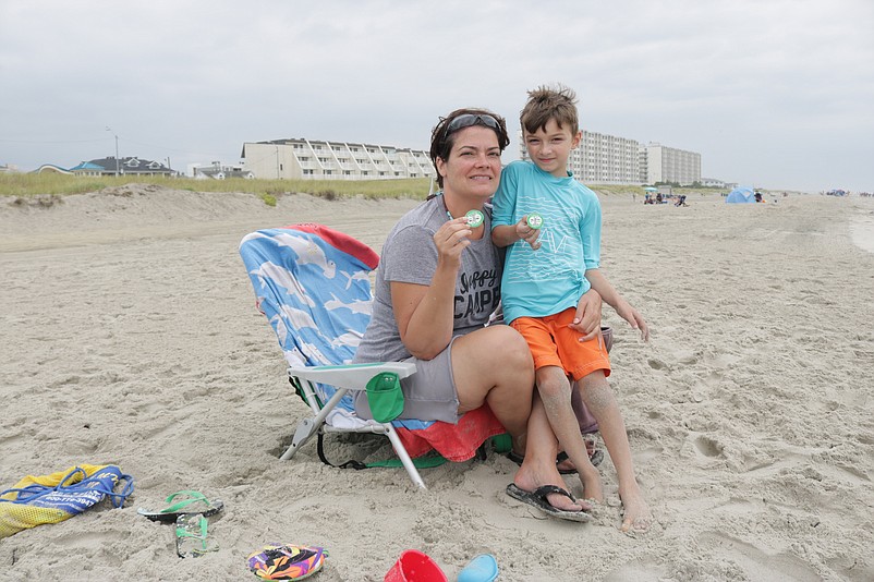 Michelle Vassallo, a Sea Isle City vacationer from Washington, D.C., and her 7-year-old son, Alex, hold up the family's beach tags last summer.