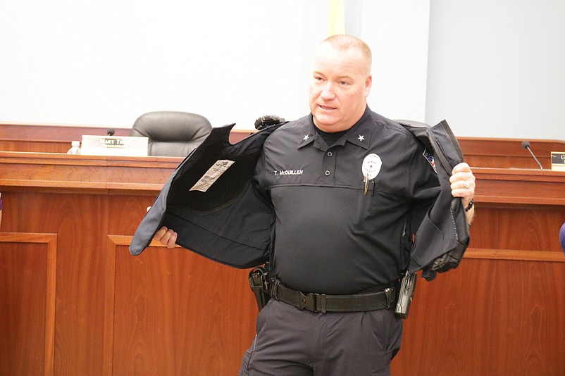 Police Chief Tom McQuillen demonstrates how easy it is to put on and take off the new body armor vests.