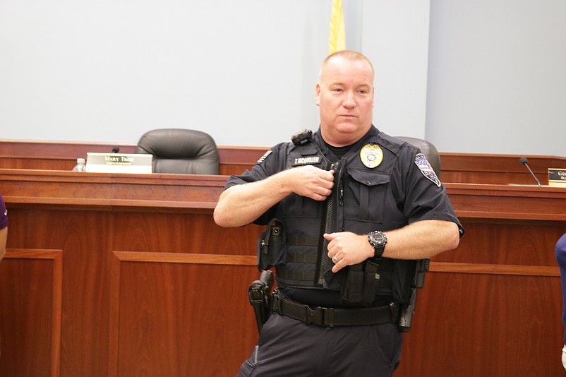 Police Chief Tom McQuillen demonstrates how easy it is to put on and take off body armor vests in 2019.