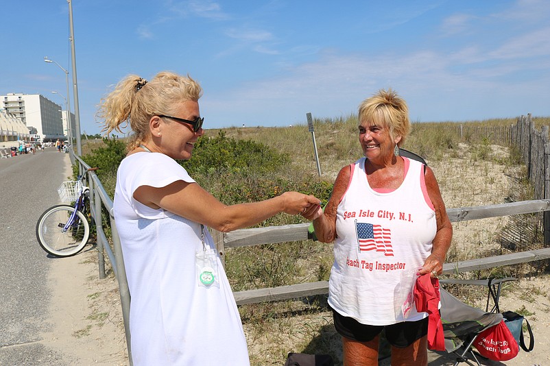 Vacationer Stephany Murphy, of Stamford, Conn., shows her beach tag to Sea Isle beach badge inspector Kathy McFarland over the Labor Day weekend in 2019.