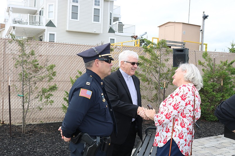 Maura Fernandez, Michael Cullinane's sister, greets Deacon Joseph Murphy and Sea Isle Police Capt. Anthony Garreffi after the service.