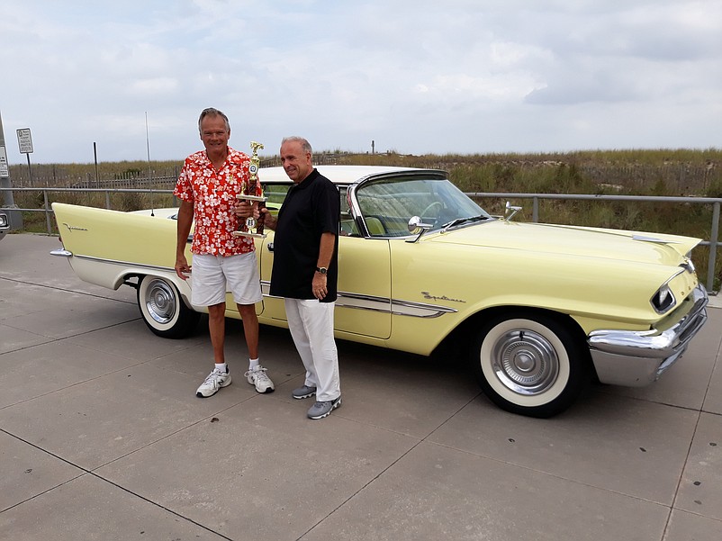 Perry Rogers, left, of Collegeville, Pa., receives the Mayor's Choice trophy from Mayor Leonard Desiderio for the 1957 DeSoto Firedome.