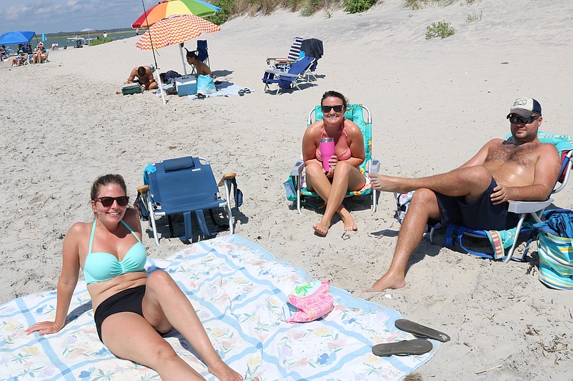 From left, Melissa Ferry, Michelle Grossman and John Byrne, all of Ridley, Pa., enjoy the beach while squeezing out the last few hours of the Labor Day weekend.