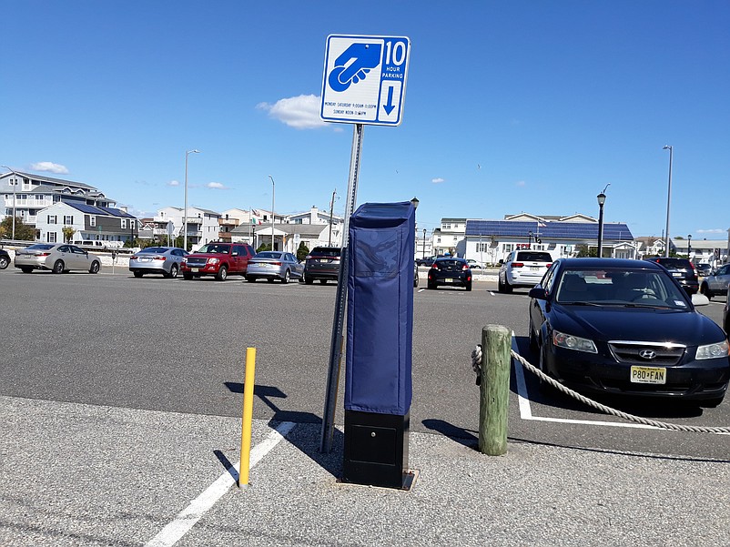 Navy blue fabric covers have been draped over all 49 of the city's parking kiosks for the off-season months.