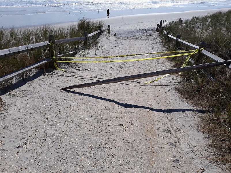 Yellow caution tape blocks the way on the footpath leading to the eroded 43rd Street beach.