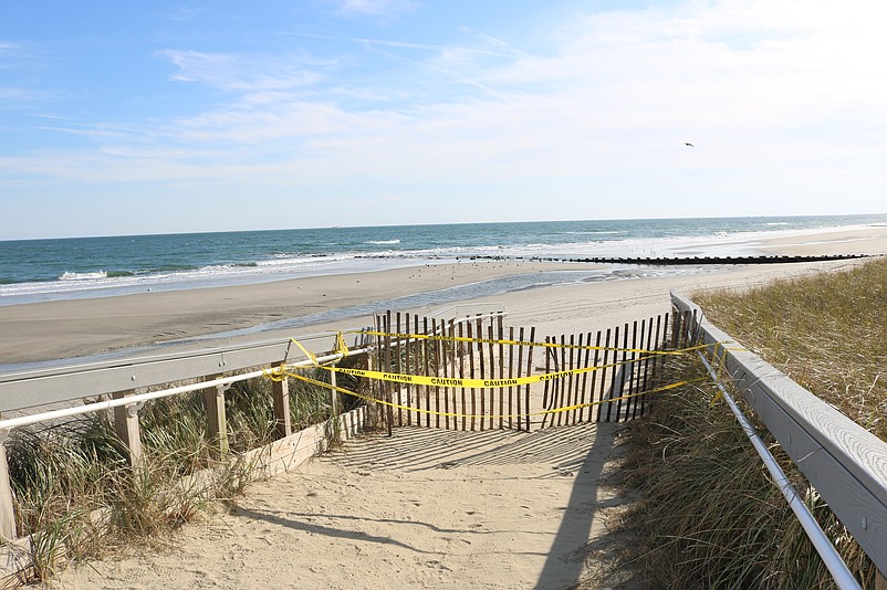 Some pathways to the beach are blocked off to prevent people from venturing out where there are steep drop-offs in the storm-damaged dunes.