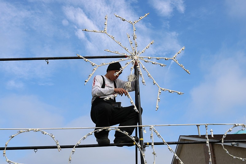 Johnny Alvarado fastens a snow flake to the frame.