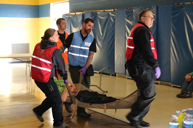 Sea Isle City Police Sgt. John Salzman, middle, with emergency responders take victim out of the former school in the training drill.