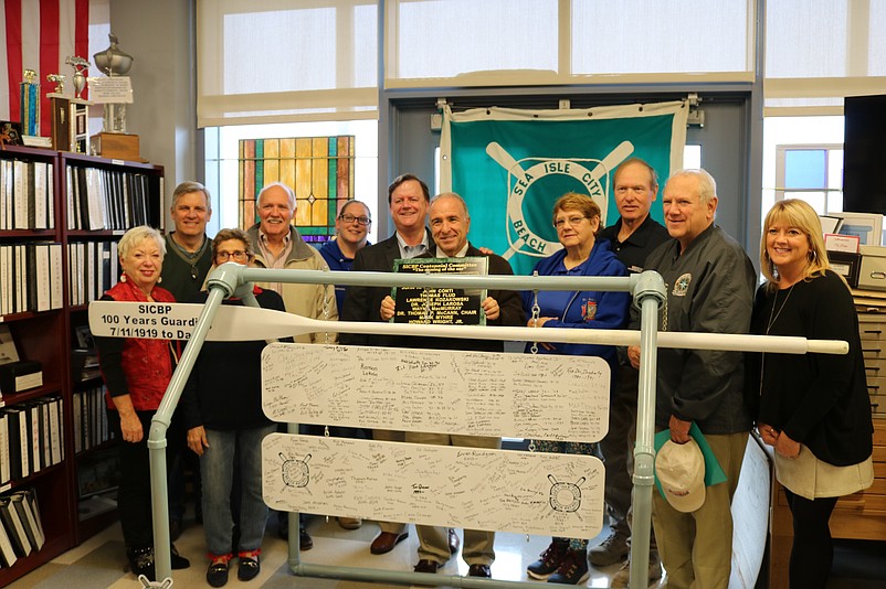 Mayor Leonard Desiderio, center, is joined by past and present members of the Beach Patrol and Historical Museum members while standing behind the commemorative display.