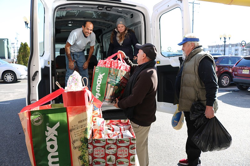 The mayor and volunteers load the bags into the van ready to make deliveries to the families in need.