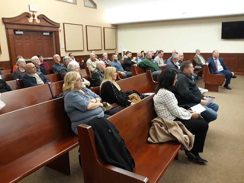 The audience listens to a presentation on the hotel during the zoning board meeting